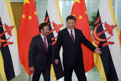 Chinese President Xi Jinping shows the way to the meeting room to Brunei