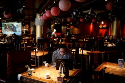 A man looks at his laptop after having lunch at a restaurant during lunch hour, as the country is hit by an outbreak of the new coronavirus, in Beijing, China 6 February, 2020. (Photo: Reuters/Carlos Garcia Rawlins).