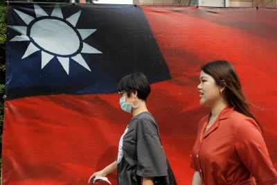 People walk past a Taiwanese flag amid COVID-19 in Taipei, Taiwan, 10 August 2020 (Photo: Reuters/Ann Wang).