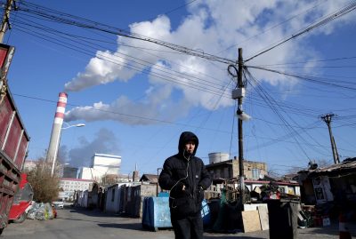 A man walks near a coal-fired power plant in Harbin, China, 27 November 2019 (Photo: Reuters/Jason Lee).