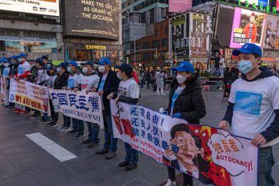 Pro Chinese democracy activists holds banners during a China Democracy Party demonstration at Times Square, New York City, United States, 13 March 2021 (Photo: Reuters/Ron Adar)
