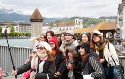 Participants of a tour group of 4000 Chinese tourists take pictures in front of the Chapel Bridge during their visit to the central Swiss city of Luzern, Switzerland. (Photo: Arnd Wiegmann/Reuters)