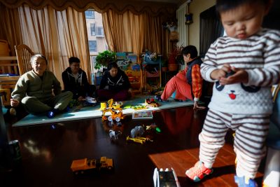 Tang Huajun, Ang Ran and her parents sit near their 2-year-old son Tang Ziang at their home in Beijing, China, 8 November 2022 (Photo: Reuters/Tingshu Wang).