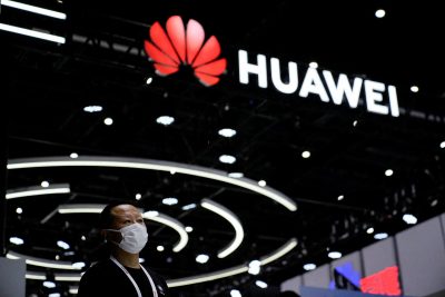 A person stands by a sign of Huawei during World Artificial Intelligence Conference, following the COVID-19 outbreak, in Shanghai, China, 1 September 1 (Photo: Reuters/Aly Song).