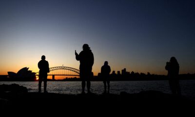 Silhouettes of people, the opera house and harbour bridge are seen during sunset ahead of the Women's World Cup, Sydney, Australia, 17 July 2023 (Photo: Reuters/Carl Recine)